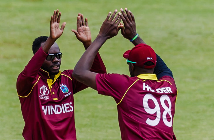 Windies spinner Nikita Miller celebrates a wicket with skipper Jason Holder during a warm-up cricket match between the Windies and UAE, at Harare Sports Club last Thursday. (Windies Crickrt photo)