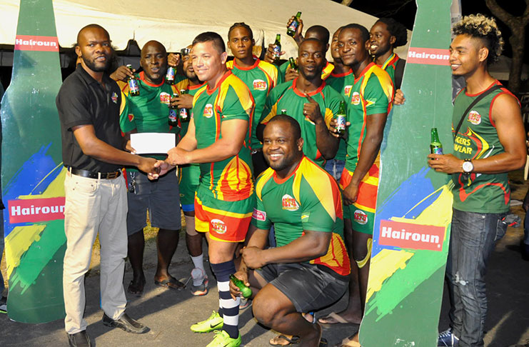 CHAMPS! Pepsi Hornets captain Ryan Gonsalves collects the winners’ purse of US$1000) after defeating Harvard Rugby Club 10-0 to win the GRFU Hairoun Beer Sevens tournament. (Delano Williams photo)