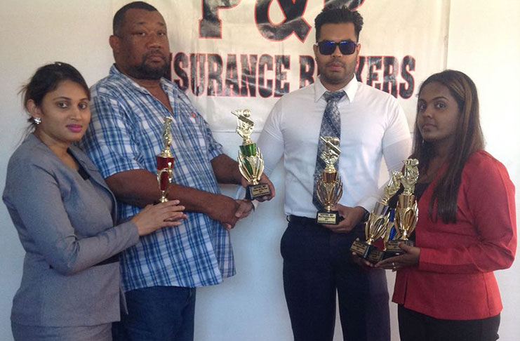 Mr V. Panday of P&P Insurance Brokers donates trophies to CEO Hilbert Foster.