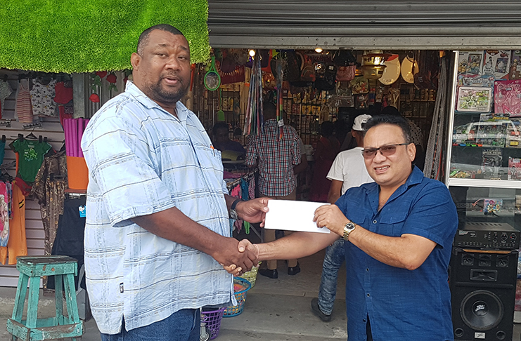 BCB president Hilbert Foster receives the sponsorship from Bissoondyal Singh.