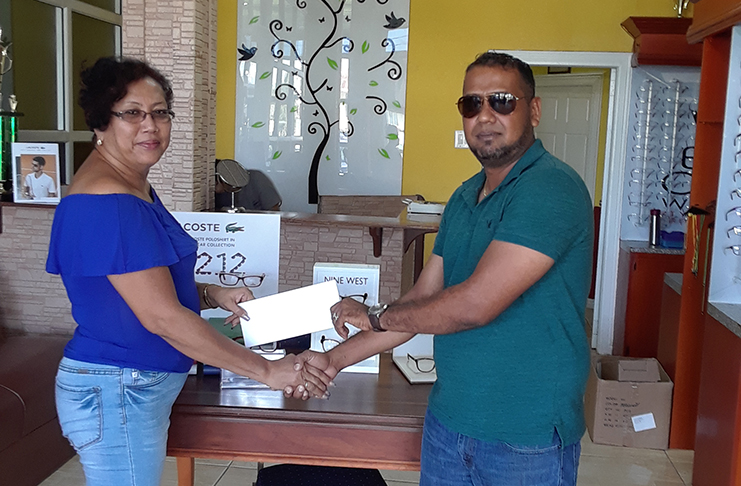 Desiree Lee, GMR&SC executive (left) collects the sponsorship for the Miracle Optical Sports Tuner cup from Christopher Singh. 