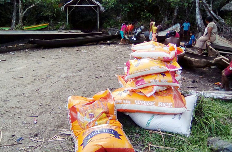 Traders prepare to load several bags of rice to be ferried across the Venezuela border at “Gaja Landing” at White Water on Thursday afternoon