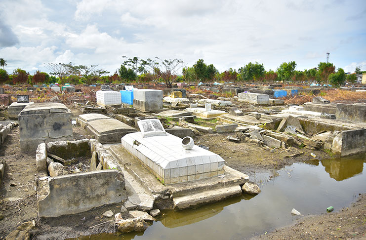 Broken tombs at Le Repentir cemetery. Stagnant water is also visible at the cemetery (Samuel Maughn photo)