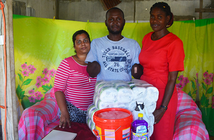 Representative of the Department of Education, Region Four Welfare Department, Ms. Rhonda Monize, right, with Mr. and Mrs. Melroy Pyle