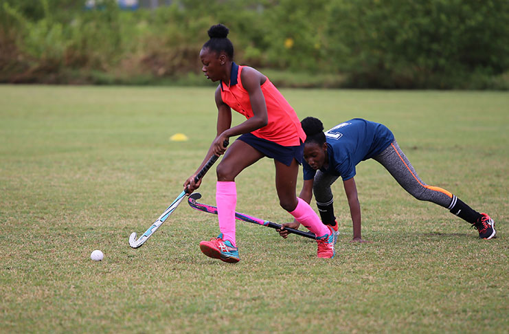 Bingo Spartans striker Abosaide Cadogan (red) eliminates a Saints defender.