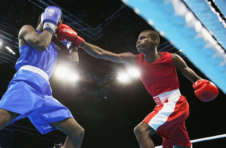 Guyana’s Colin ‘Superman’ Lewis (right) connects to Nathan Ferrari of St Lucia, during their Light Welterweight encounter at the Commonwealth Games.