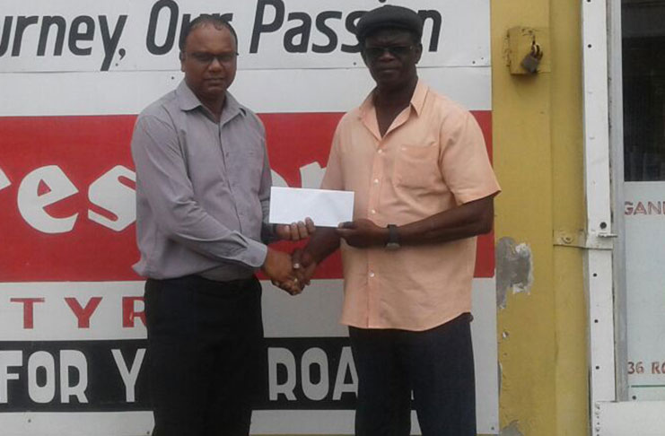 Sales Manager at Ganesh Parts, Suresh Rampersaud, (left) hands over the sponsorship to Chairman of the Boyce/Jefford Committee, Colin Boyce yesterday outside the Robb Street store.