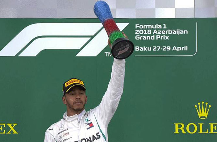 Mercedes' Lewis Hamilton celebrates with a trophy on the podium after winning the race REUTERS/David Mdzinarishvil
