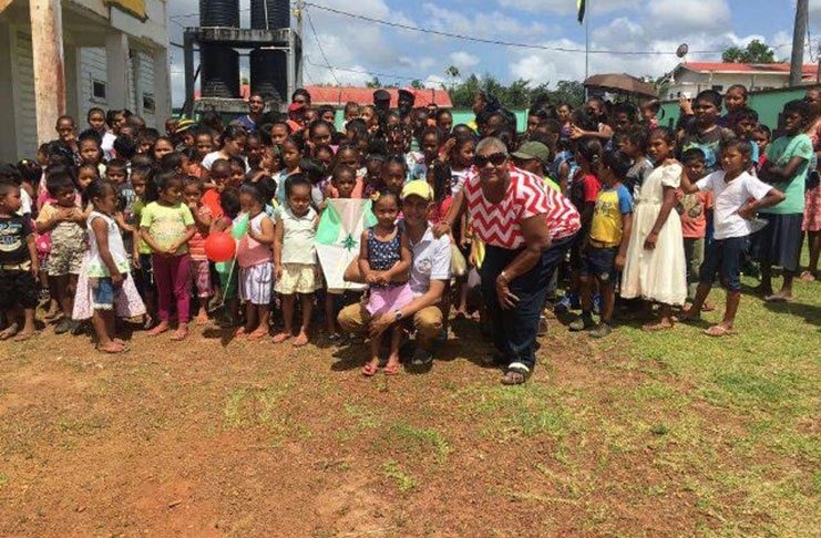 Minister of Communities Ronald Bulkan and APNU+AFC Member of Parliament Rajcoomarie Gloria Bancroft, with some of the Region Eight Primary School children
