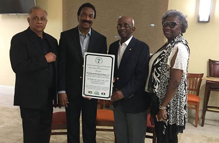 Chairman of the PNCR, Basil Williams, SC., receives a plaque from the Florida NAR group of the PNCR