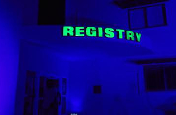 The Registry building of the University of Guyana lit in blue