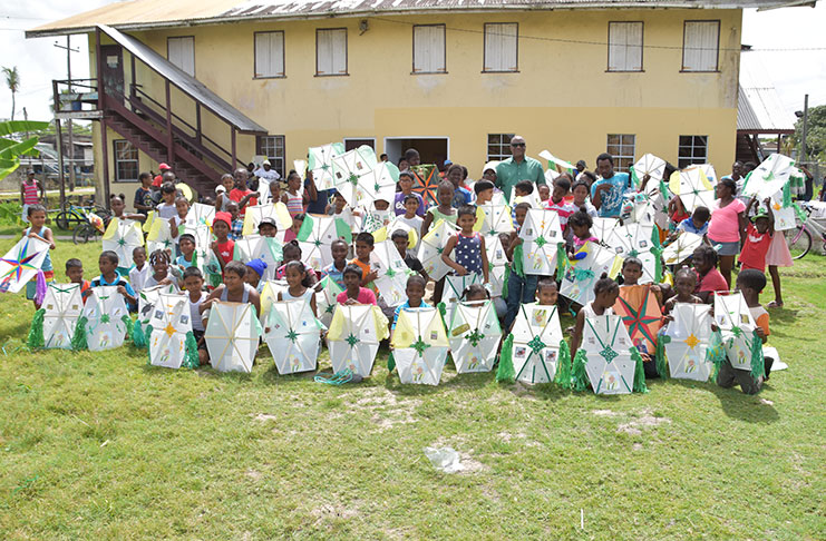Minister of State Joseph Harmon with children during the kite distribution exercise on Friday