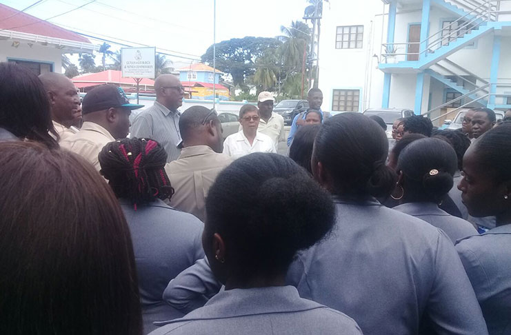 GGMC Commissioner Newell Dennison and Board Chairman Stanley Ming (centre) engaging staffers in the GGMC compound on Monday