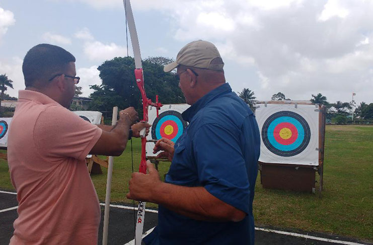 Ganesh Singh, visually-impaired, prepares to take his first archery shot under the guidance of coach Phil Graves.