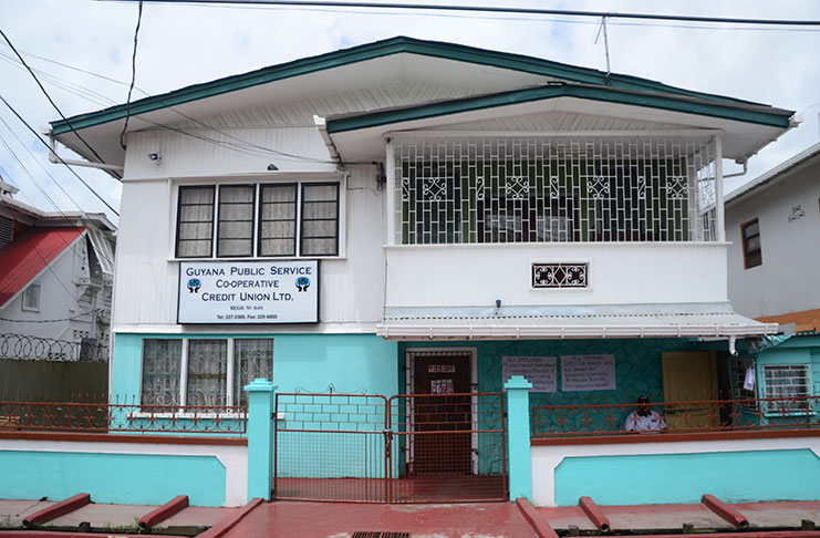 The padlocked Guyana Public Service Co-operative Credit Union (GPSCCU) Hadfield Street office, with an ISS security guard safeguarding the premises. 
Photos by Delano Williams