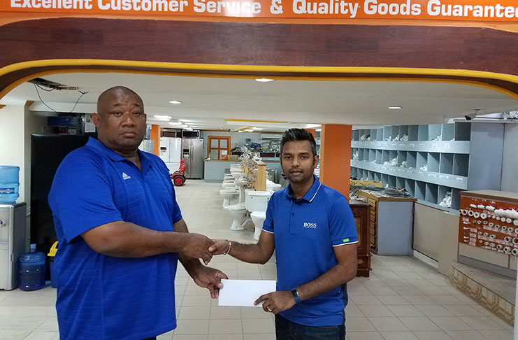 BCB president Hilbert Foster collects the sponsorship cheque from Javed Raffik.