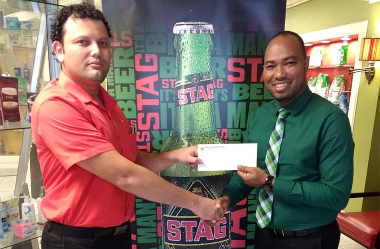 Ansa McAl’s Nigel Worrell (right) makes a presentation of its title sponsorship for the May 20 event to Pepsi Hornets’ Roger Perreira,