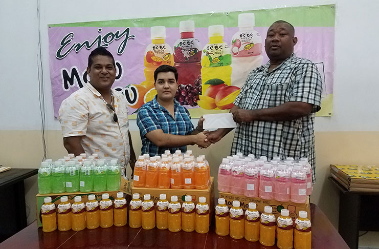 Sean Rodrigues of Sueria Manufacturing hands over sponsorship to BCB president Hilbert Foster while his CEO Frank Sanichara looks on.