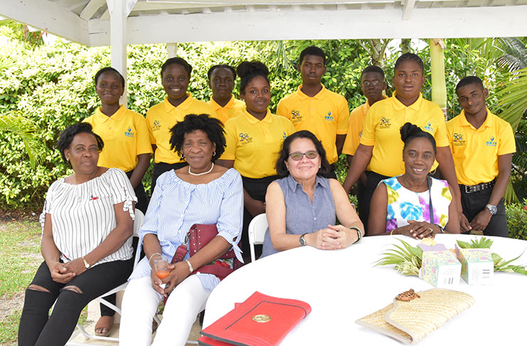 First Lady, Mrs. Sandra Granger (seated third from left) is joined by Co-ordinator of Women Across Differences (WAD), Ms. Clonel Samuels-Boston (seated, first right) and others guests at the fundraising brunch. Members of the Guyana Bank for Trade and Industry (GBTI)-Buxton Steel Pan Orchestra are pictured standing. 