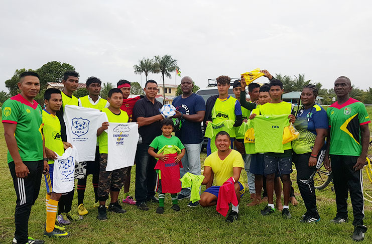 EBFA president Franklin Wilson hands over the balls to Laluni Primary School’s Headmaster Anthon Abrams in the presence of players who are displaying some of the donated items. EBFA TDO Devnon Winter is at left and right, Orein Angoy and Amanda Angoy.