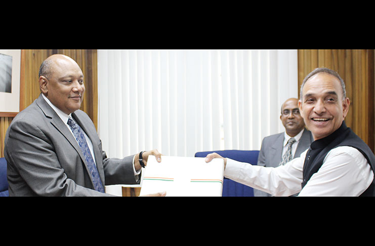 Minister of Natural Resources Raphael Trotman receives a gift from India's Minister of State for Human Resource Development and Water Resources, River Development and Ganga Rejuvenation, Dr. Satya Paal Singh on Tuesday