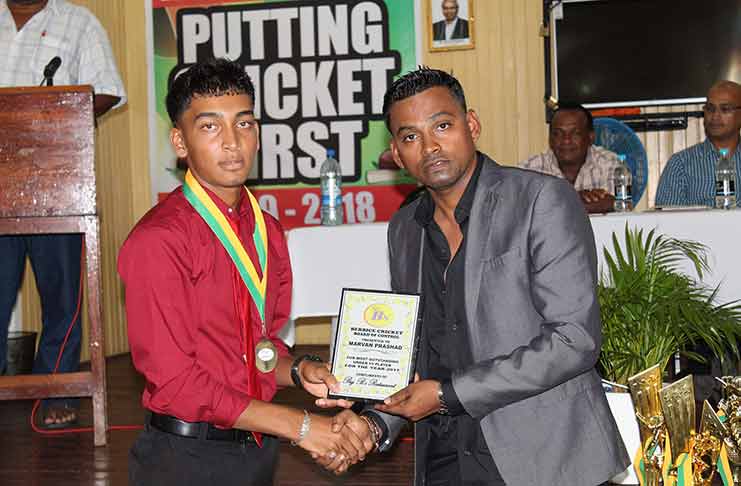 Marvan Prashad (left) receives his BCB award for most outstanding Under-15 Player-of-the-Year from Shabeer Baksh, president of BCCC