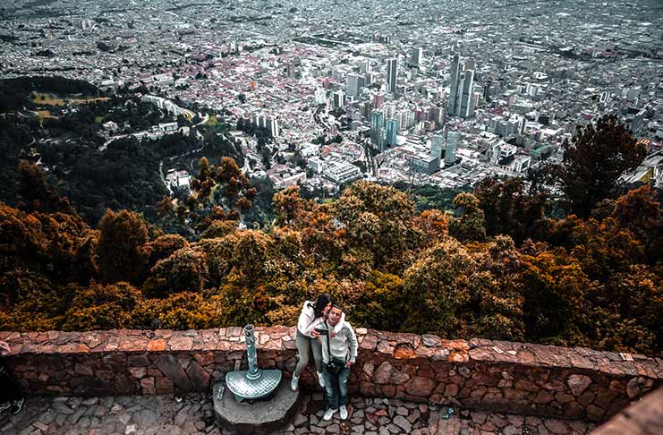young couple caught taking a selfie of the panoramic view on the walls of Mount Monserrate