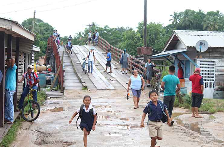 Children in the Kumaka community of Moruca, in Region One, rush over the ‘Moruca Bridge’ to get home after school