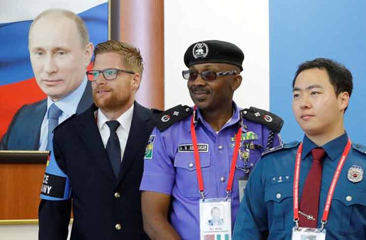 Law enforcement officers take part in the opening of the International Police Cooperation Centre ahead of the 2018 FIFA World Cup, with a portrait of Russia's President Vladimir Putin seen in the background, in Domodedovo, near Moscow, Russia yesterday, 2018. (REUTERS/Sergei Karpukhin)