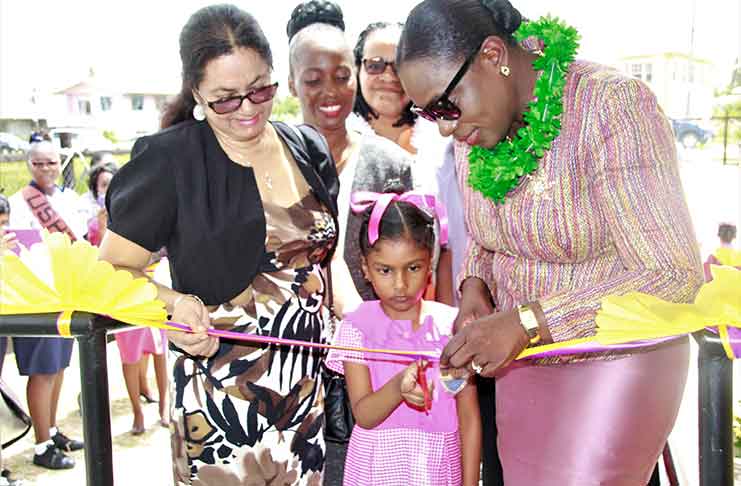 Minister of Education Nicolette Henry, assisted by Mr. Roopchand’s widow cuts the ribbon along with a student of the school to the Eastville Nursery School, while in the background is Nursery Education Officer, Smemlyn Batson-Andrews and REO Lucas