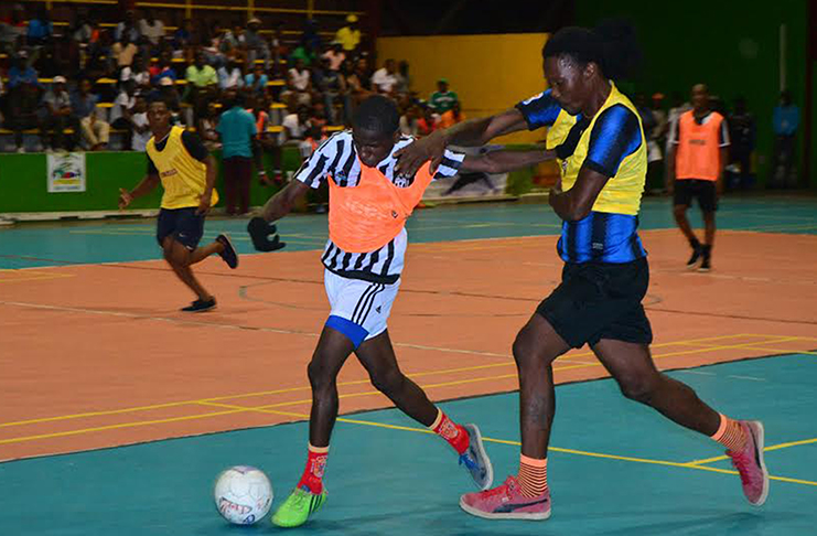 FLASHBACK! Lennox Cort (left) of Albouystown tussles with Gerald Gittens of North Ruimveldt for possession of the ball at the National Gymnasium.