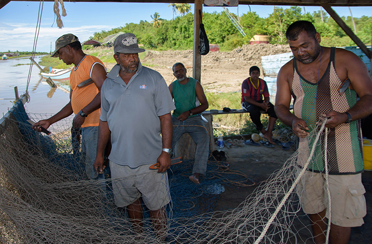 Boyo (first right) and his colleagues knitting their fishing nets while contemplating what would have happened if the bridge toll increase were granted (Samuel Maughn photo)