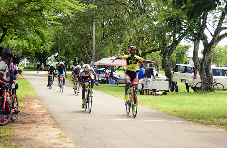 Team Coco’s Jamual John celebrates as he crosses the finish line ahead of Christopher Griffith to cop the feature event of the 18th Annual P&P Insurance Brokers cycling meet. (Adrian Narine photo)