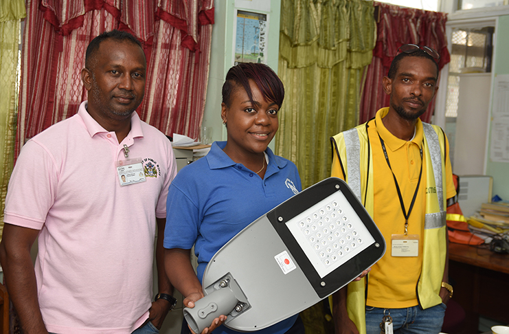 Secretary of the Traffic and Highway Lights Department Thandi Fortune (centre) displays one of the new LED Lamps in the presence of Electrical Engineers Lallram Seeram (left) and Andre Lindore (Samuel Maughn Photo)