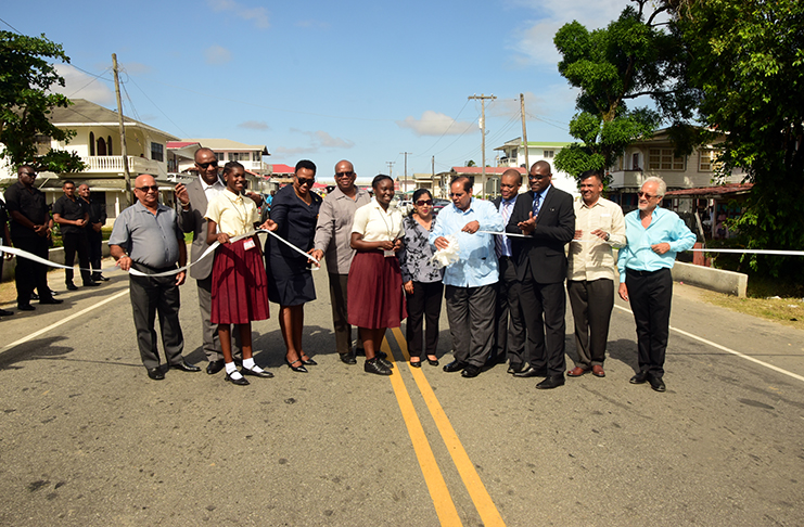 Prime Minister Moses Nagamootoo (fifth from right) assists in cutting the ribbon to officially commission the project. Minister of State , Joseph Harmon  (second from left ); Regional Executive Officer , Denis Jaikarran (left) and Minister  of Public Infrastructure , David Patterson (third from right ) also assisted in the event.