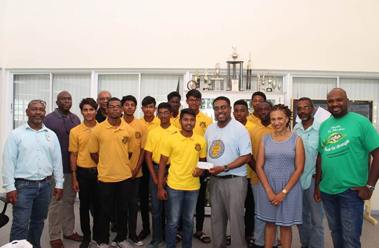 Captain of the Queen’s College cricket team and student, Amos Sarwan, receives the cheque of $1M from alumnus Dr. Terrence Blackman alongside the rest of the team, other QC alumni and Chairman Alfred Granger (fourth from left)