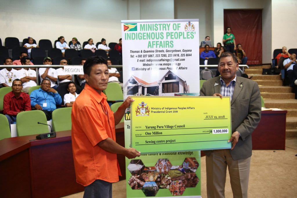 Toshao of Yarung Paru Village, Region Nine, Shevnarine Cyprian receiving the presidential grant from Indigenous Peoples’ Affairs Minister Sydney Allicock (DPI photo)