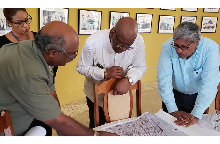 Finance Minister Winston Jordan and DDL Chairman Komal Samaroo, listen as DDL Projects Manager Kenneth Ragnauth explains the layout of the new facilities in the DDL expansion programme
