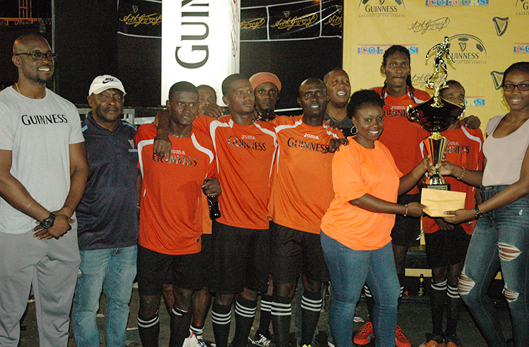 Colours Boutique’s Creanna Damon hands over the first prize and trophy to West Front Road 'Gold is Money' representative in the presence of teammates and Guinness Brand Manager Lee Baptiste (left) on Saturday.

 