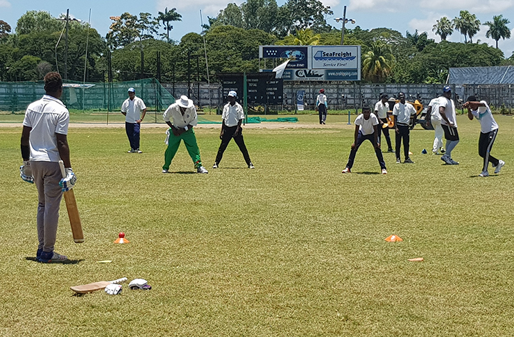 Technical director of the programme, former Guyana batsman Mark Harper gives some advice to a few participants.