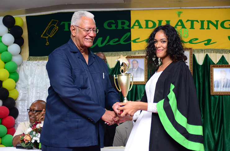 Minister of Agriculture, Hon.  Noel Holder presents a trophy to Top Performer Alleema Shahabudeen.