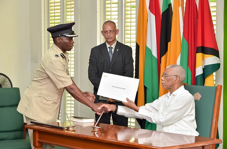 Newly-installed Commissioner of Police Leslie Albert James receiving his instrument of appointment from President David Granger