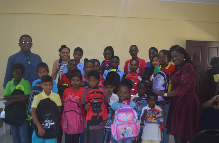 REDO (acting) Tiffany Favourite-Harvey along with Regional Vice Chairman Earle lambert and Regional Executive Officer (REO) Pauline Lucas with some of the students who received bag packs