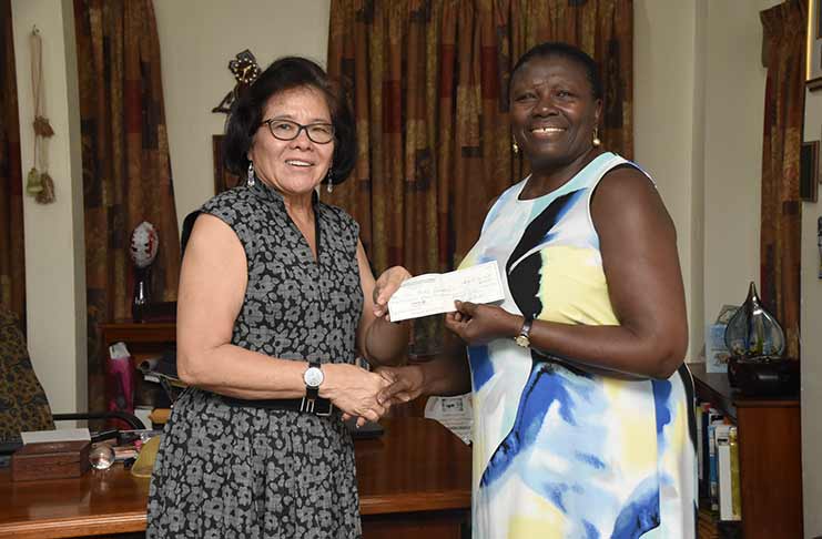 First Lady, Mrs. Sandra Granger accepts the cheque from Beryl James, Secretary of the Guyana United Youth Development Association (GUYDA)