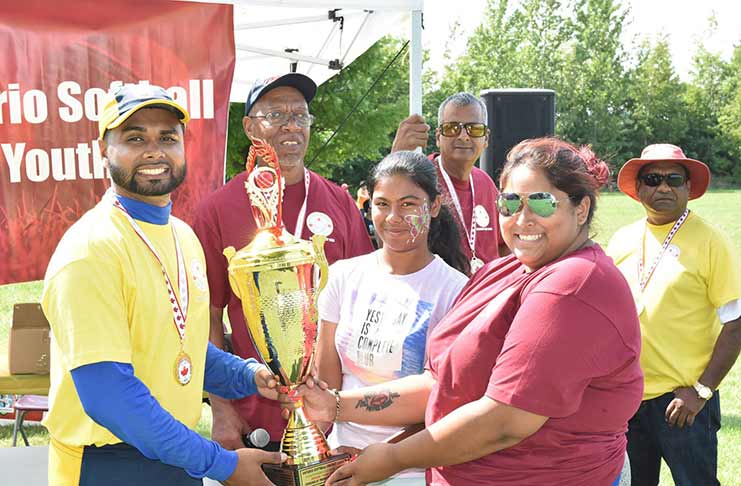 Jaguars skipper Shiv Persaud collects the winning trophy from Nyssa Narine in the presence of OSCL officials.
