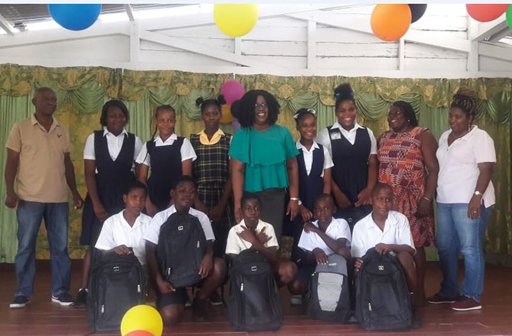 Minister within the Ministry of Public Health, Dr. Karen Cummings and officials pose with the students who received bursary awards