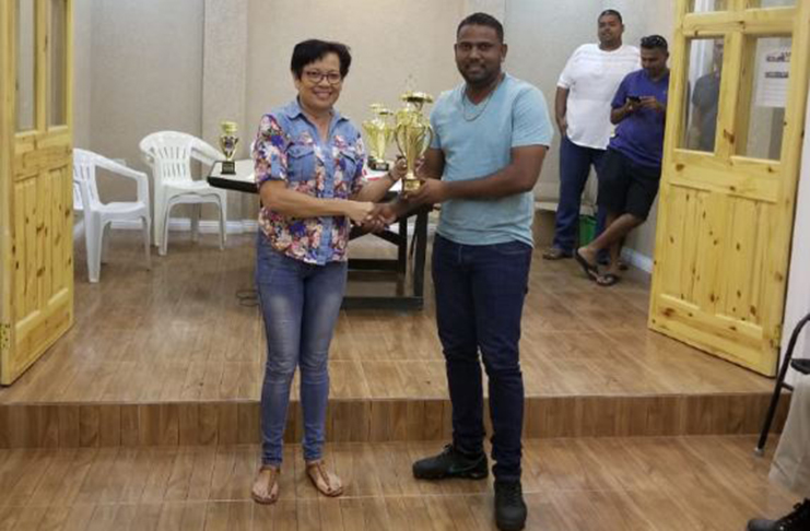 Pierre Singh (right) collects his trophy from GMR&SC office executive Cheryl Gonsalves.