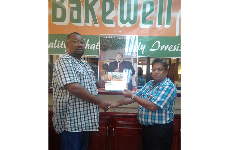 BCB president Hilbert Foster receives sponsorship from Bakewell General Manager Rajin Ganga.