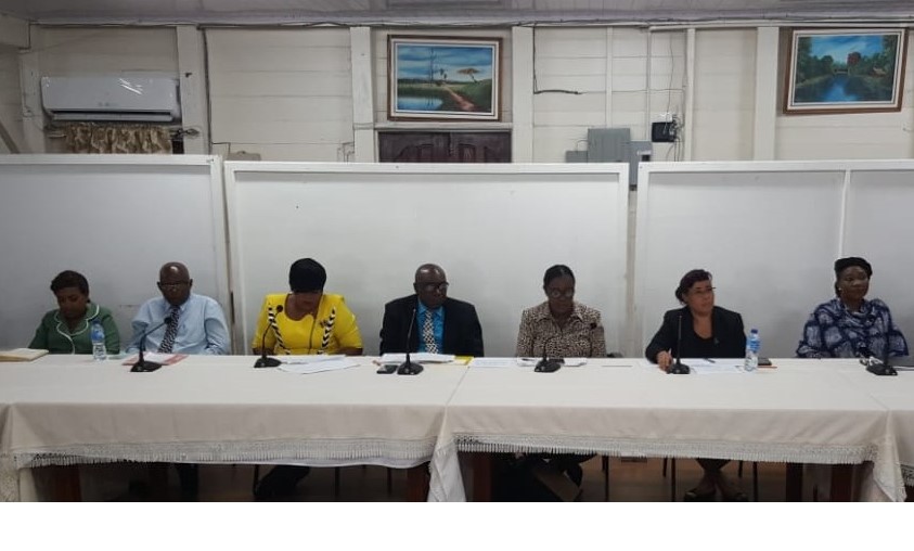 Minister of Education , Nicolette Henry  (third from right ) sits next to Chief Education Offcier , Marcel Hutson (fourth from right ) and other education ministry officials at Monday night's press briefing.