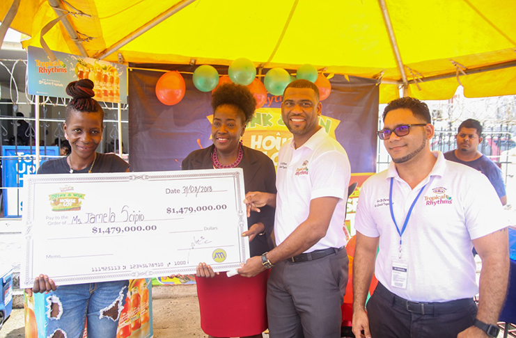 Grand prize winner Jamela Scipio, as she was presented a cheque by representatives of Ansa McAl while the Minister with responsibility for Housing, Valerie Adams-Yearwood, looks on.
